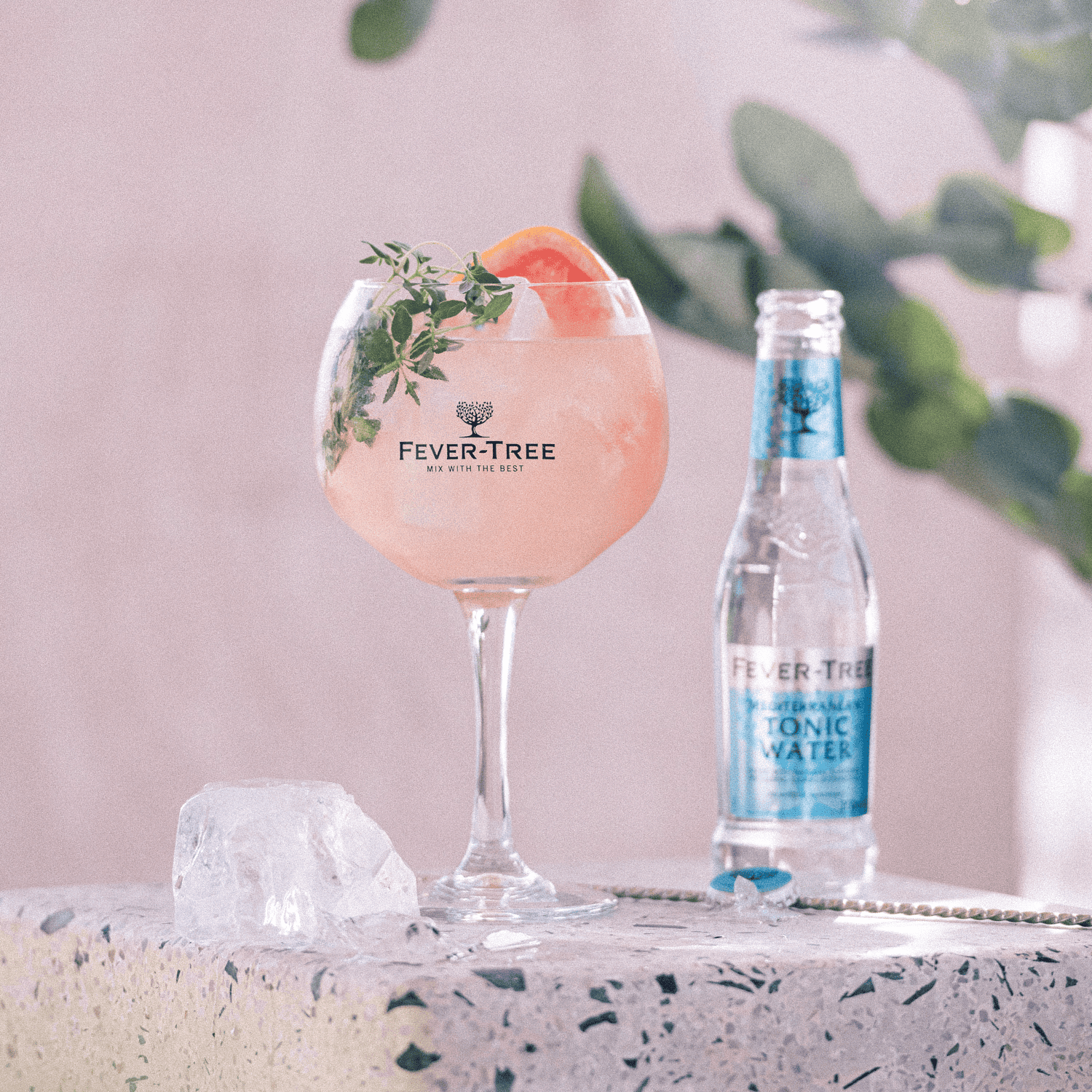 Cocktail rosa con Tonic Water Fever Tree e decorazioni verdi.