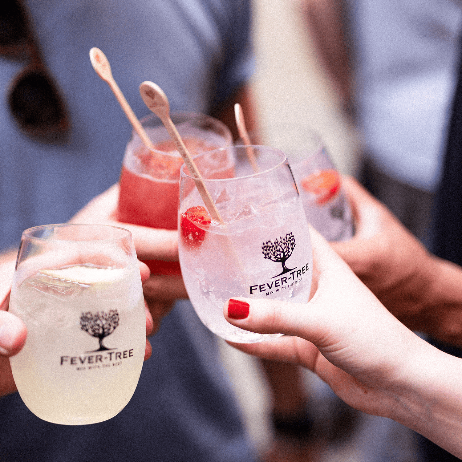 Persone che brindano con cocktail Fever Tree in un evento sociale.