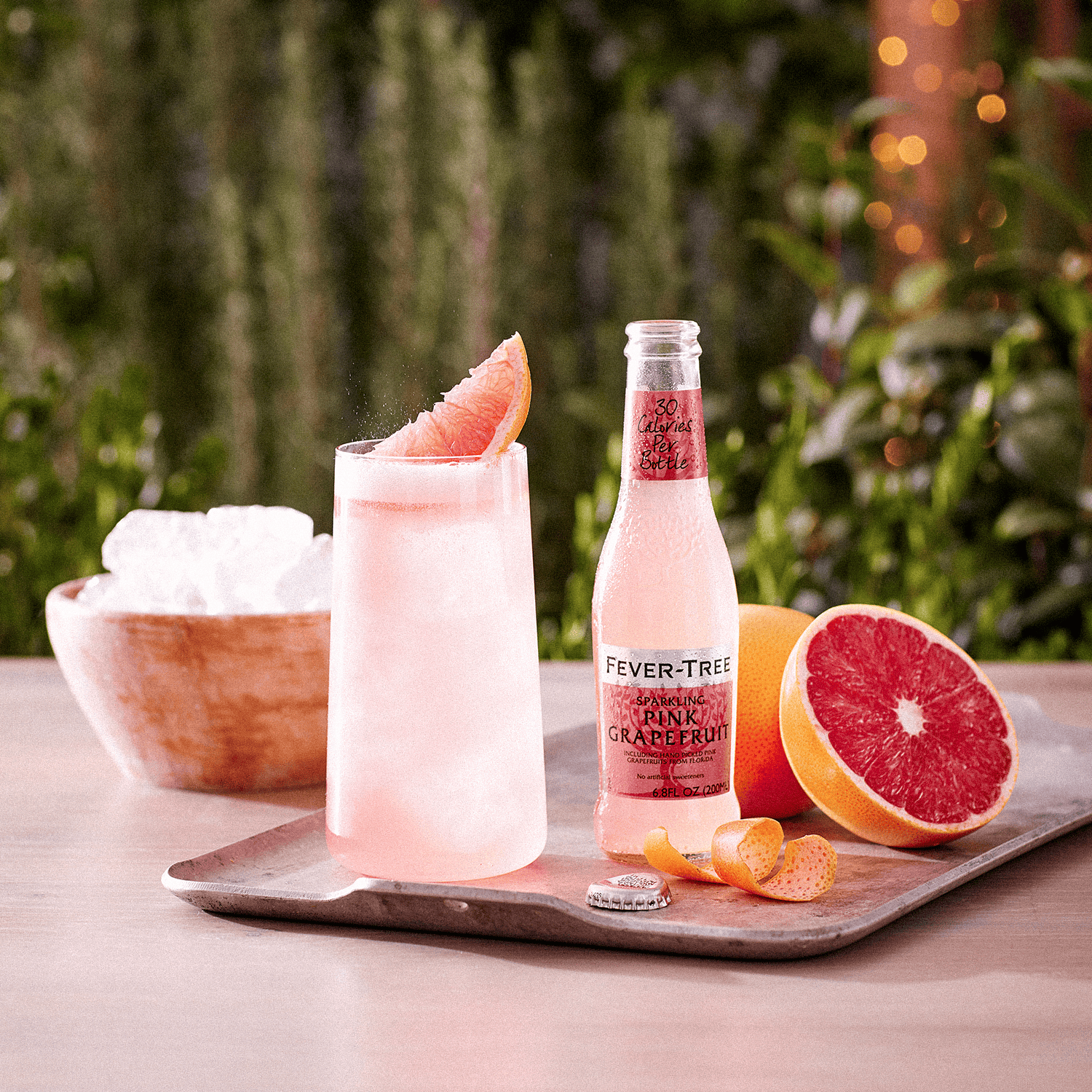 Bottiglia di Fever Tree Pink Grapefruit con drink e frutta fresca.