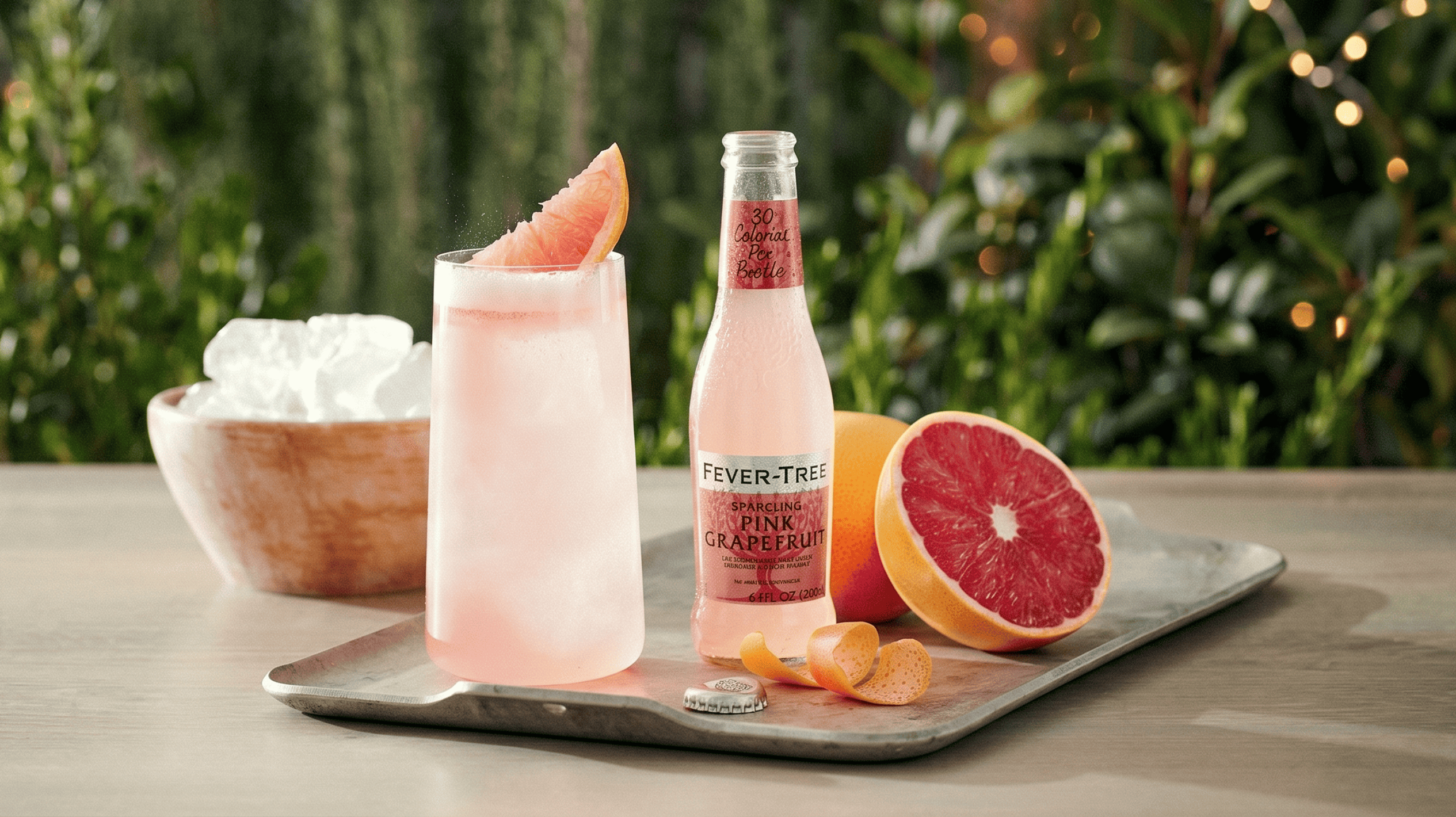 Cocktail rosa con Fever Tree e pompelmo rosa, decorato con fetta di pompelmo.