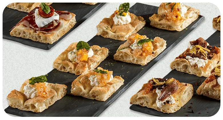 Varietà di crostini gourmet su piatto nero, perfetti per aperitivi eleganti.