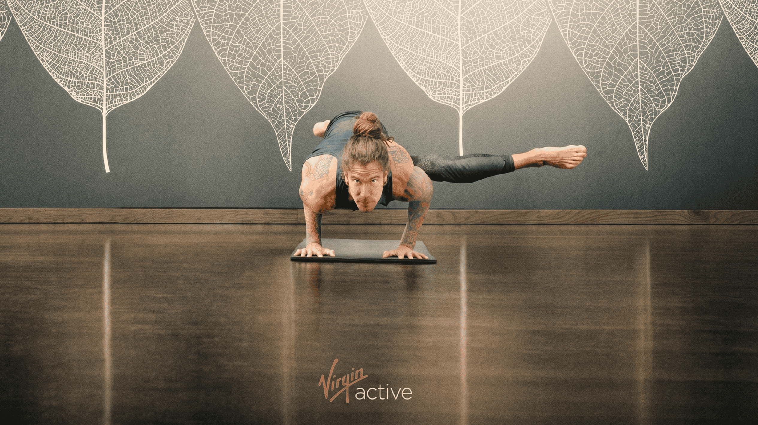 Donna in equilibrio su una mano durante una sessione di allenamento di yoga.